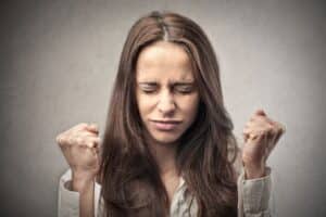 An angry woman, eyes closed, fist closed