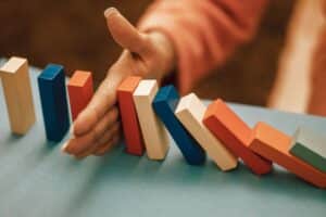 A domino line stopped by a hand to prevent them from falling