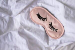 eye cover for sleeping time on a white bed sheet
